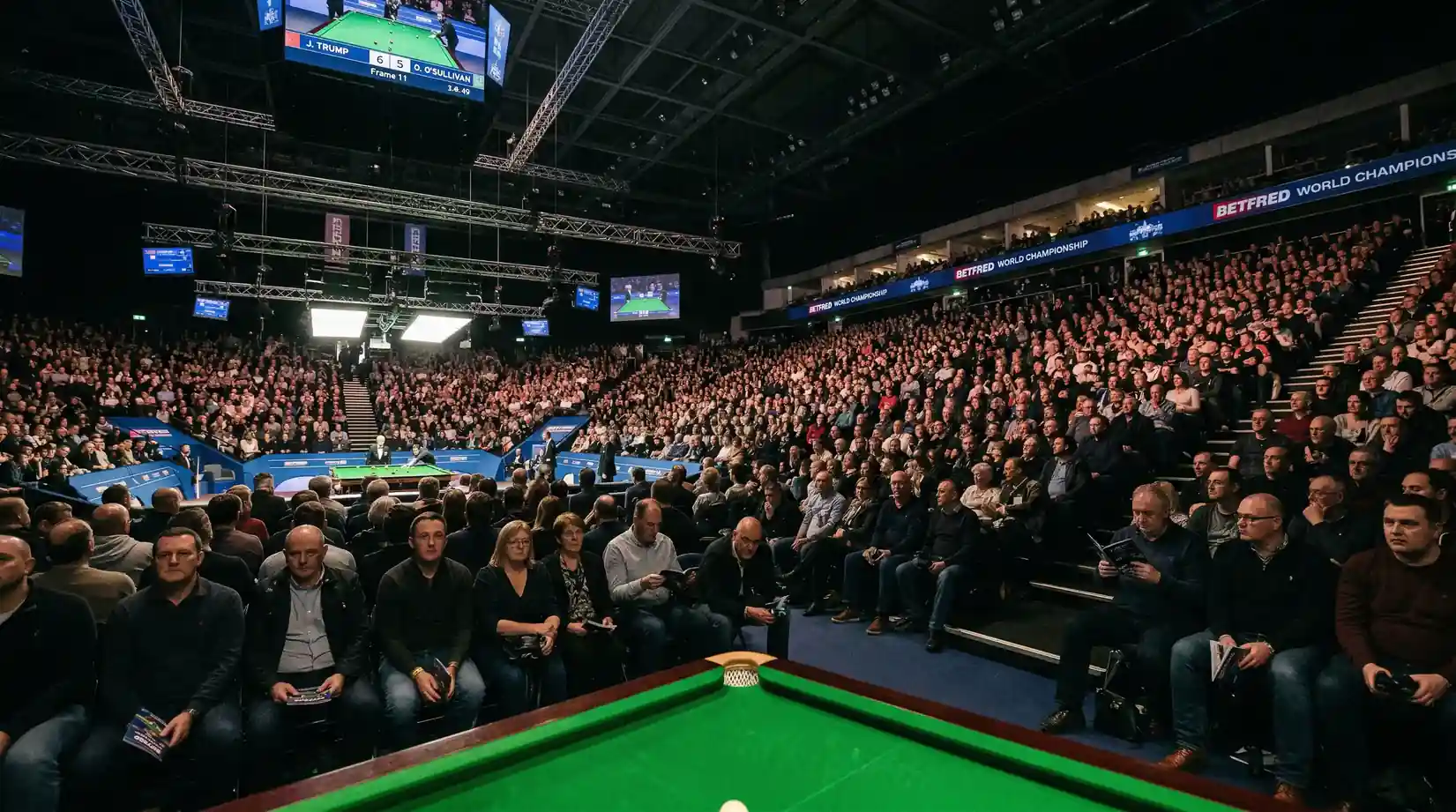 Volle tribune met publiek dat een professionele snookerwedstrijd bekijkt in een verlichte arena